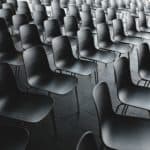 a room full of empty black chairs