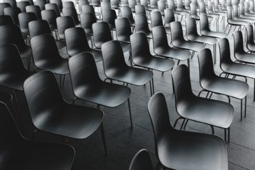 a room full of empty black chairs