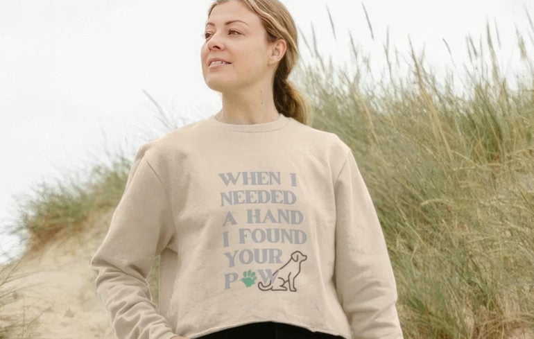 Woman on the beach wearing an ability dogs jumper