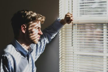 depressed man looking out of the window