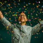 man throwing colourful confetti