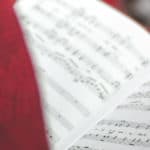 person signing in church holding open a song book by david beale