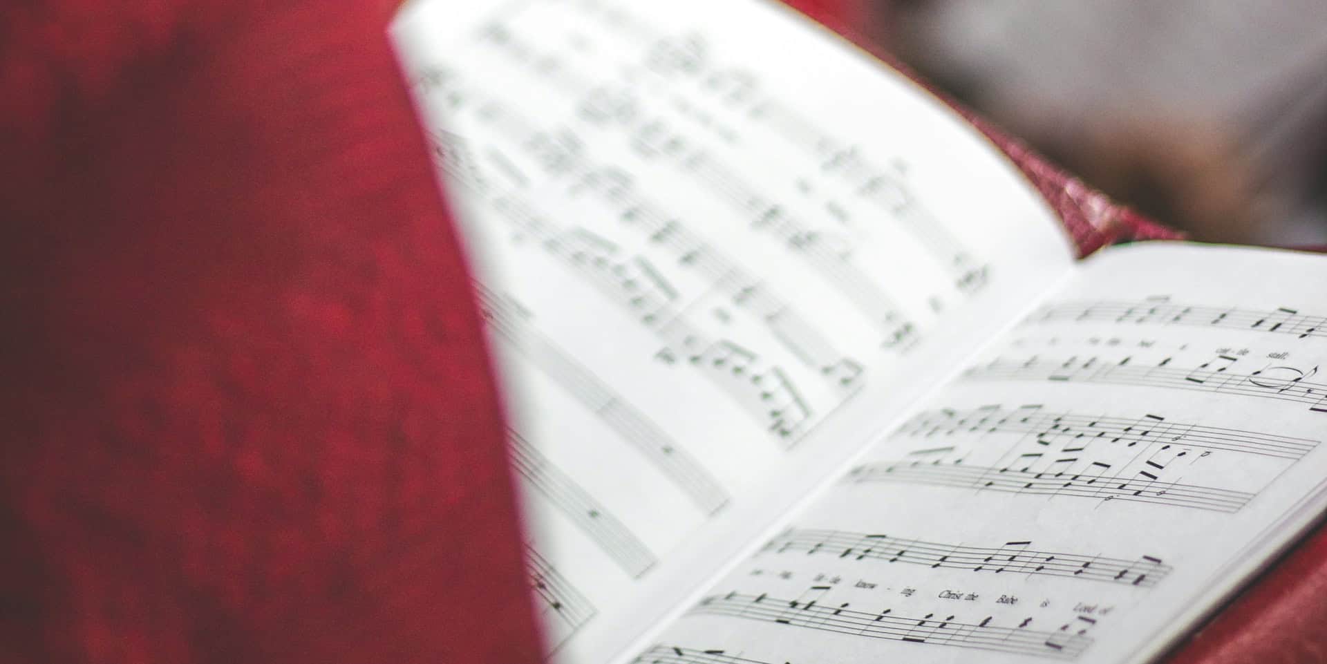 person signing in church holding open a song book by david beale