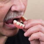 Man removing false teeth