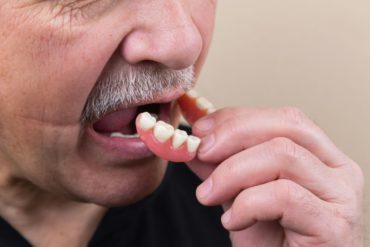 Man removing false teeth