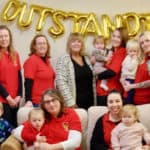 Staff and pupils at the Nursery with large gold balloon that reads 'Outstanding'