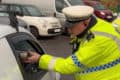 Police officer operating a breath test on a driver through the window-hq-width-1200px