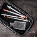 hypodermic needles and glass bottle