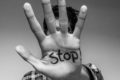 man holding out his hand with stop written on his palm