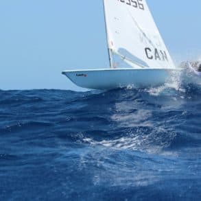 person hanging off side of yacht