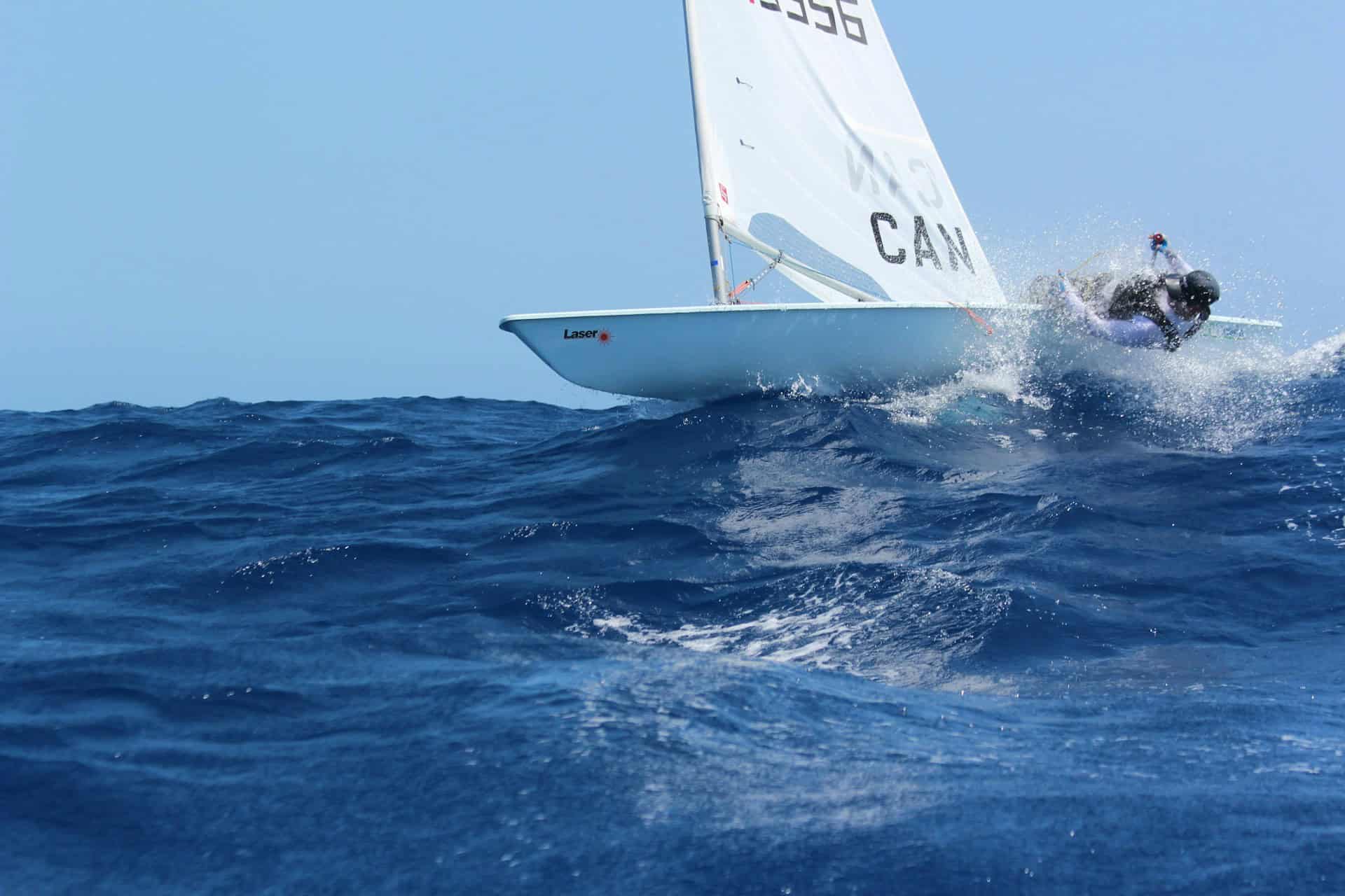 person hanging off side of yacht