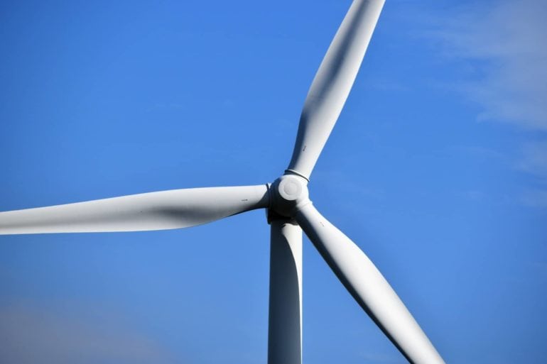 wind turbine blades against a blue sky