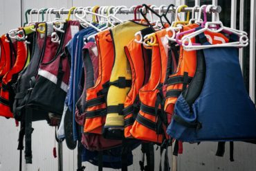 A rail of lifejackets and buoyancy aids