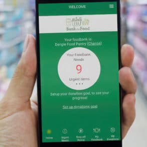 Person holding a mobile phone in a supermarket with Bank the food app