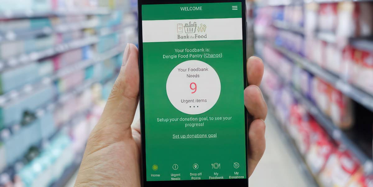 Person holding a mobile phone in a supermarket with Bank the food app