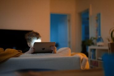 Child on a bed looking at an ipad