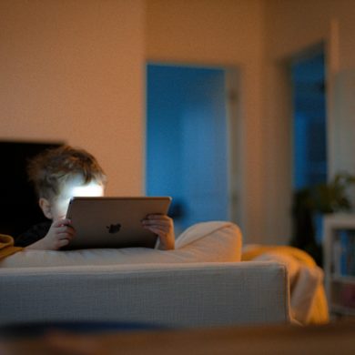 Child on a bed looking at an ipad