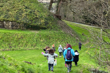 children at carisbrooke castle exploring the ladnscape