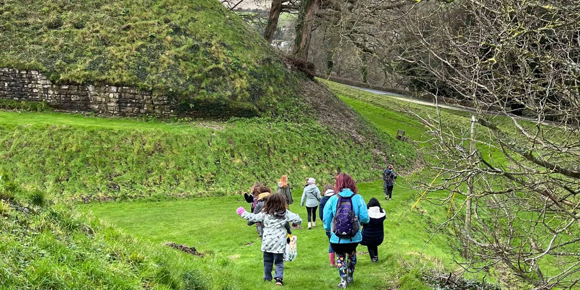 children at carisbrooke castle exploring the ladnscape