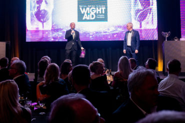 Tom Stroud on stage presenting Wight Aid award