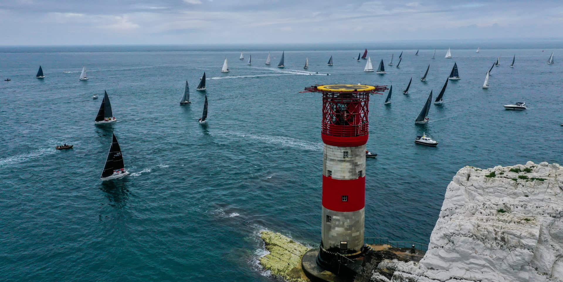 Aerial shot of round the island race boats going around the Needles