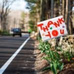 a hand written thank you sign at the side of the road