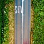 aerial view of road and green fields by red zeppelin