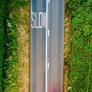 aerial view of road and green fields by red zeppelin