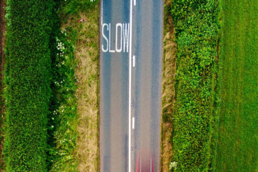 aerial view of road and green fields by red zeppelin