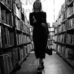 black and white photo of woman in library by anastasiya badun