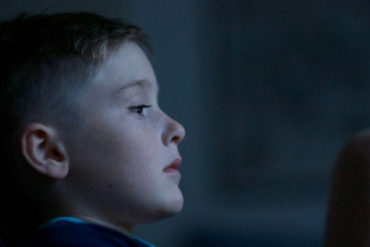 young boy child leaning against wall looking sad and lonely by luke pennystan