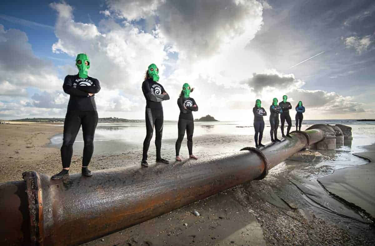 SAS swimmers standing on sewage pipe leading out to sea