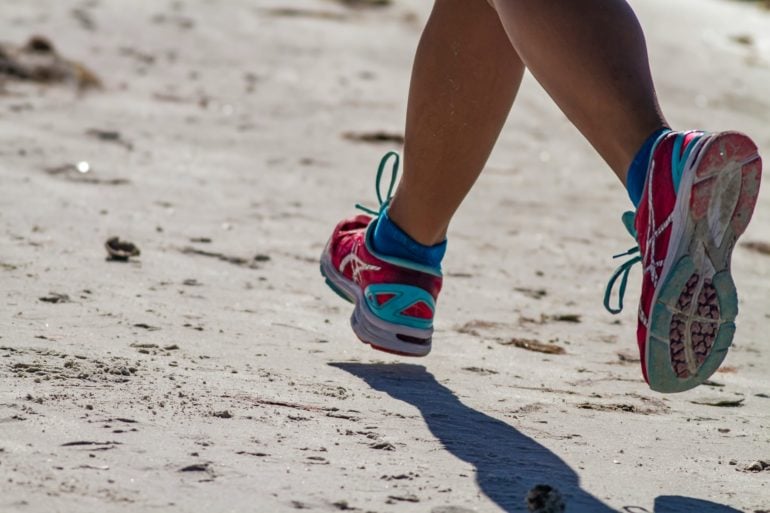 Woman running on the beach by dulcey lima