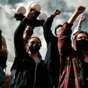 a group of people with their arms in the air fists clenched