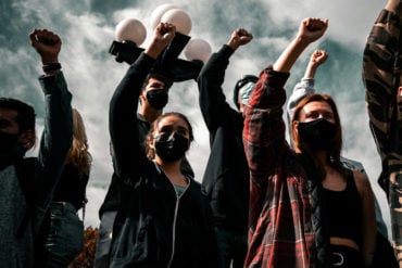 a group of people with their arms in the air fists clenched