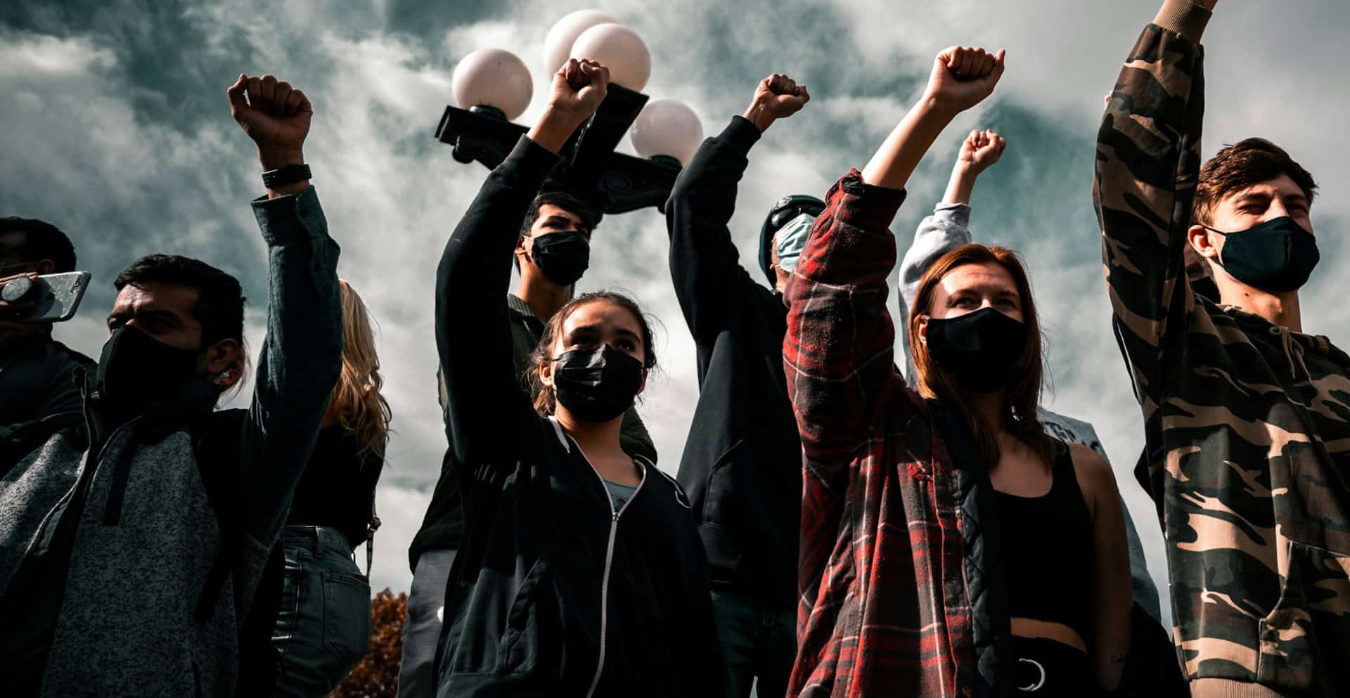 a group of people with their arms in the air fists clenched