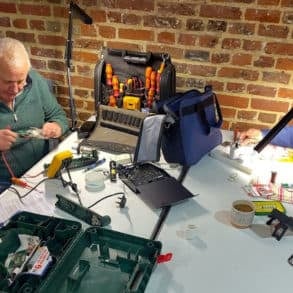 men working on electronics repairs at the repair cafe