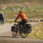 person on bicycle with shopping in side bags