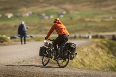 person on bicycle with shopping in side bags