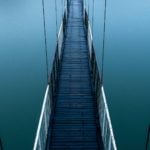 wooden bridge over blue lake