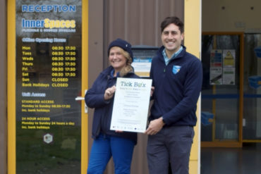 Innerspaces staff with certificate showing they are signed up to the Tick Box scheme