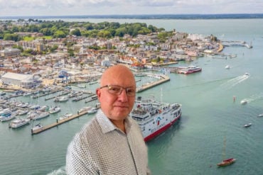 Neil Chapman portrait on background image of Red Funnel ferry leaving Cowes