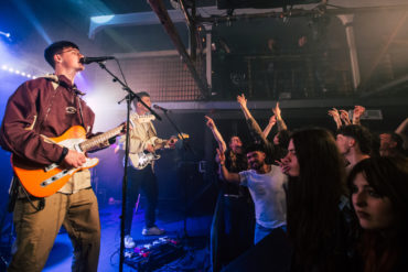 The Optimists playing on the stage at Strings Bar and Venue by David Rutherford