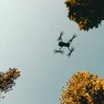 drone flying near tree tops by kyle loftus