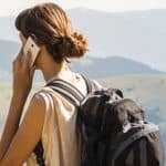 back of a woman in the mountains on a mobile phone