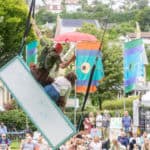An audience in Ventnor Park watching a physical theatre performance