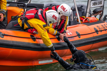 RNLI volunteers rescuing someone out of the water