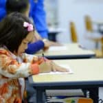 a primary school pupils sat working at a desk