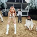wet leg band members posing in front of a house in the country