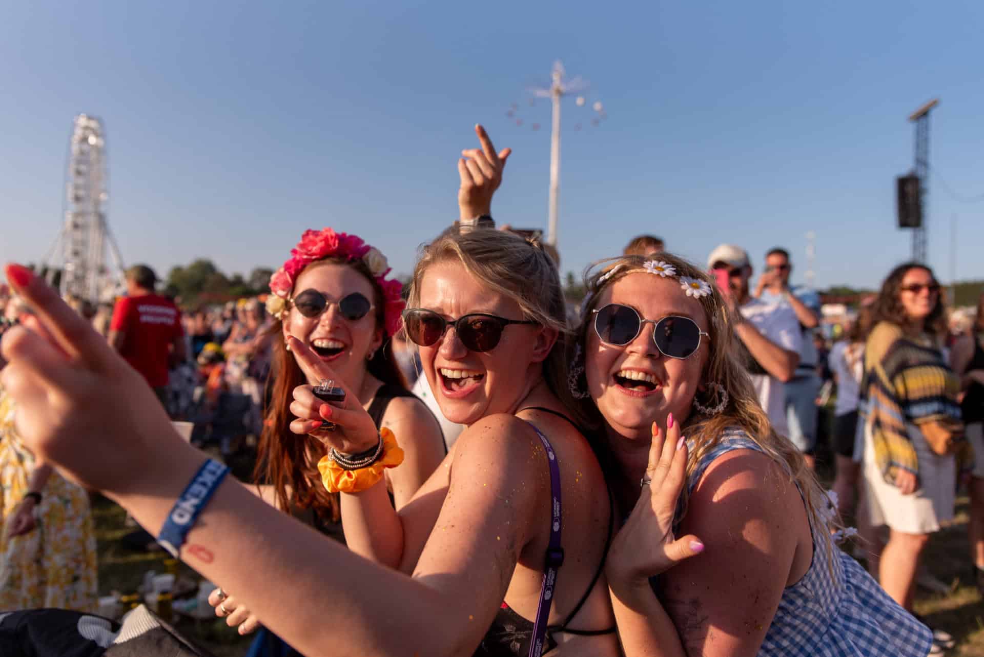 Festival-goers with flowers in their hair smiling for the camera